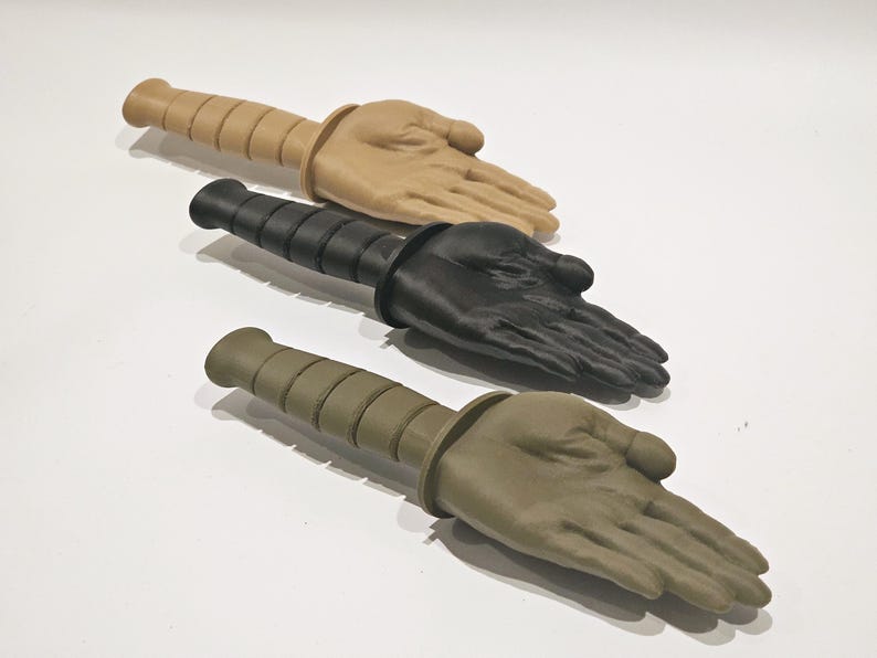May include: Three training knives with different colored handles. The handles are made to look like a hand. The knives are beige, black, and green.