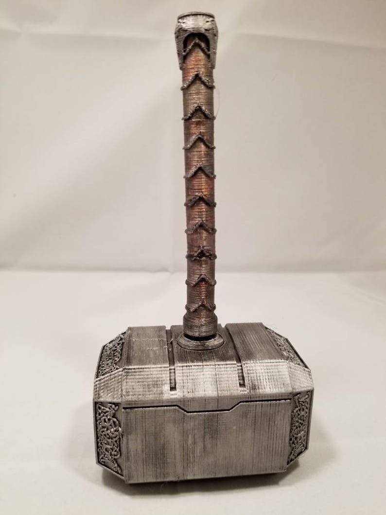 Op de afbeelding: Een zilverkleurige Mjolnir-hamer met een bruine houten handvat. De hamer is een replica van het wapen dat door de Noorse god Thor werd gezwaaid.
