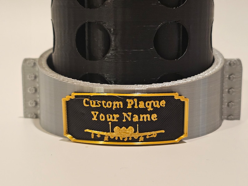 May include: A black and gold custom plaque with the text "Custom Plaque Your Name" and a decorative design.