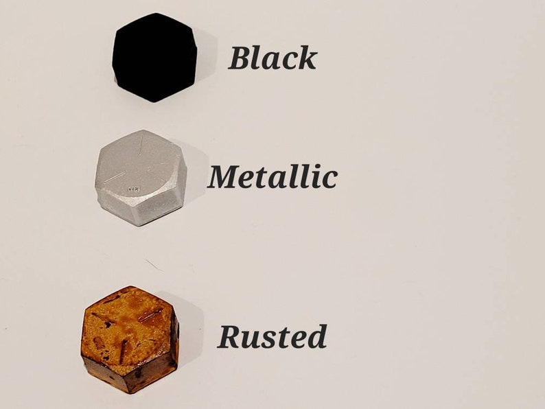 K&ouml;nnte beinhalten: Drei sechseckige Objekte werden gezeigt: eines in Schwarz, eines in Metallic-Silber und eines in Rostbraun. Das Wort "Black" steht neben dem schwarzen Objekt. Das Wort "Metallic" steht neben dem silbernen Objekt. Das Wort "Rusted" steht neben dem braunen Objekt.