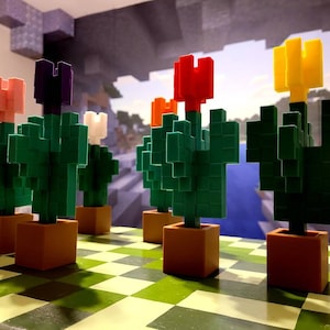 May include: Five miniature Minecraft flower pots with different colored flowers. The flowers are pink, purple, white, red, and yellow. The pots are brown and the flowers are made of small blocks.
