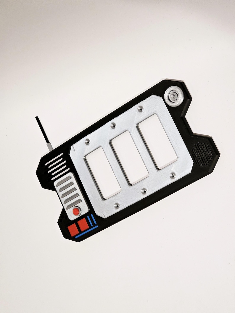 May include: A black and silver handheld device with three white buttons and a red button. The device has a small antenna and a black and blue stripe on the bottom.