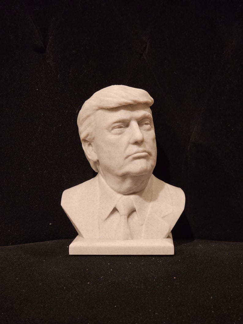 May include: A white bust sculpture of a person with short, wavy hair. The sculpture is on a white base.