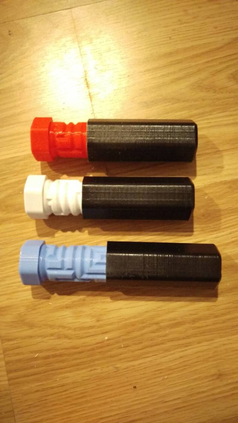 May include: Three different colored 3D printed puzzle pieces with black protective cases. The puzzle pieces are red, white, and blue.