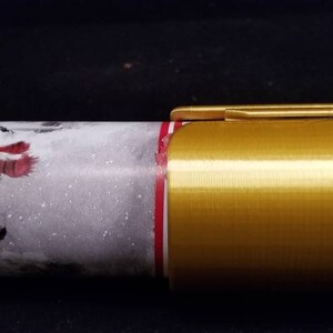 May include: Gold-colored metal wrapping paper holder with a snowman design on the wrapping paper.