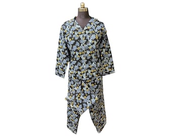 Puede incluir: Un conjunto de pijama negro con un estampado de hojas en azul y amarillo. El conjunto incluye una camisa con botones con ribete blanco y pantalones a juego. El pijama se muestra en un maniquí.