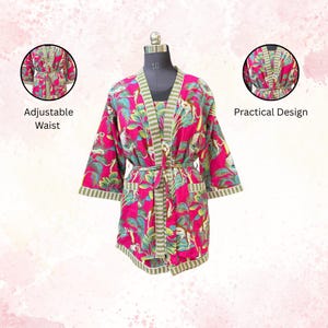 May include: A vibrant pink robe with a tropical print of green leaves and white animals. The robe has a striped green and white trim, an adjustable waist, and a practical design. The robe is displayed on a mannequin.