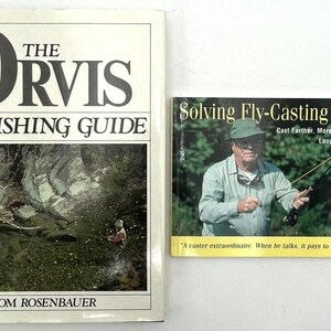 May include: Two fly fishing books, one titled "The Orvis Fly-Fishing Guide" by Tom Rosenbauer, and the other titled "Solving Fly-Casting Problems" by Lefty Kreh. The Orvis book features a photo of a stream with a person fly fishing. The Lefty Kreh book features a photo of Lefty Kreh fly fishing.