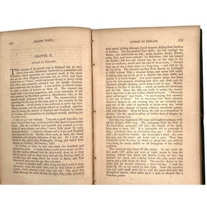 May include: A vintage book, titled "English Traits," open to a chapter on a voyage to England. The pages display aged text, with signs of wear, indicative of its age and use.