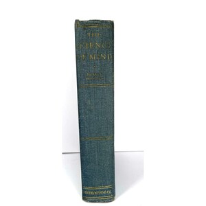 May include: A vintage book titled "The Science of Mind" by Ernest Holmes. The book has a teal cover with gold lettering and detailing. The publisher's name, Dodd, Mead & Co., is printed at the bottom.