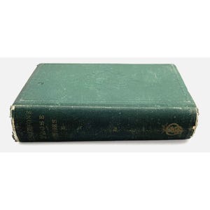 May include: An antique book with a teal-green, distressed cover. The spine of the book displays the title "EMERSON'S PROSE WORKS" in gold lettering. The cover has embossed floral detailing and shows signs of wear, giving it an aged appearance.