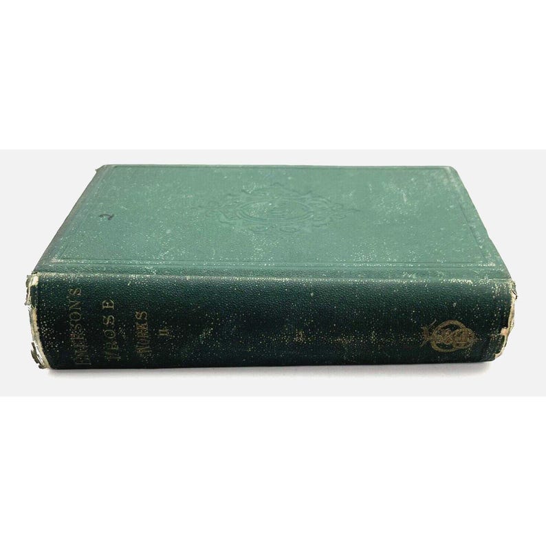 May include: An antique book with a teal-green, distressed cover. The spine of the book displays the title "EMERSON'S PROSE WORKS" in gold lettering. The cover has embossed floral detailing and shows signs of wear, giving it an aged appearance.