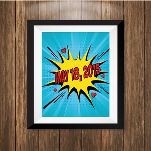 May include: A framed print with a blue background and a yellow comic book style speech bubble with the text "MAY 18, 2015" in red.