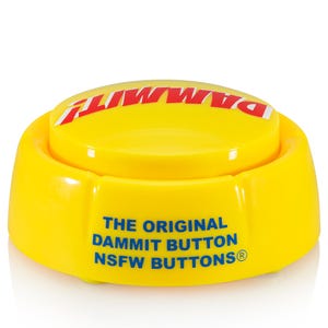 May include: A bright yellow circular plastic button with a flat top and a raised base. The top features the word DAMMIT! in bold red capital letters. The side displays the blue text THE ORIGINAL DAMMIT BUTTON NSFW BUTTONS with a registered trademark symbol.