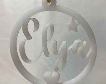 Personalized white acrylic Christmas ball, laser cut and decorated with a first name, a heart and a star.