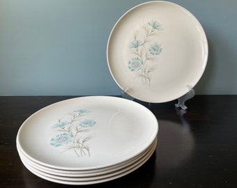 May include: Set of six white dinner plates with a blue and pink floral design. The plates are stacked on top of each other.