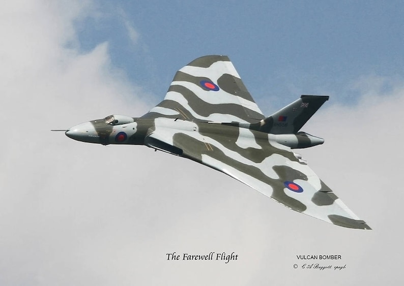 Puede incluir: Un avi&oacute;n bombardero Avro Vulcan gris y blanco camuflado vuela en un cielo azul con nubes blancas. El avi&oacute;n tiene un c&iacute;rculo rojo, blanco y azul en el ala. El texto "The Farewell Flight" est&aacute; debajo del avi&oacute;n y "VULCAN BOMBER" est&aacute; debajo de eso.