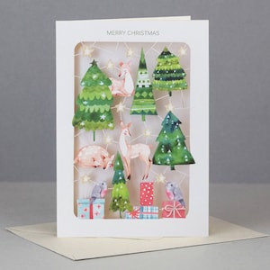 Lasergesneden kerstkaart, kerstbomen, herten, cadeautjes, sterren, kleuren, feestelijk, mooi, doorzichtige voorkant, roodborstjes,
