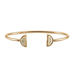 May include: Gold bangle bracelet with two half-circle charms. Each charm features a white enamel design of a sun and a moon.