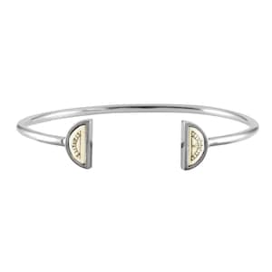 May include: A silver bangle bracelet with two half-circle charms. Each charm features a white background with a gold sun design.
