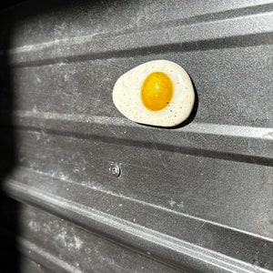 Fried egg magnet with pepper speckles