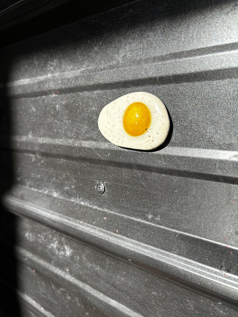 Fried egg magnet with pepper speckles