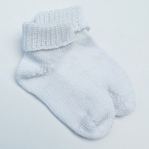 May include: A pair of white knitted socks with a folded cuff.