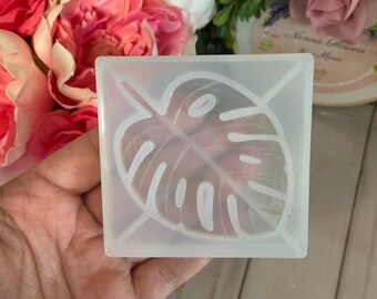 May include: A clear silicone mold with a raised design of a monstera leaf. The mold is perfect for making resin crafts.