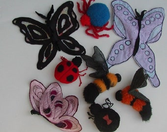 May include: A collection of felt insect and butterfly decorations. The set includes a black butterfly, a purple butterfly, a bee, a ladybug, a spider, and a black and red beetle.