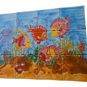 Peut inclure: Une fresque rectangulaire composée de douze carreaux de céramique représentant une scène sous-marine vibrante. L'œuvre illustre divers poissons tropicaux, une méduse, des hippocampes et des étoiles de mer sur un fond bleu avec des algues jaunes.