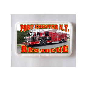 May include: A rectangular patch featuring a red and black fire truck with the text "PORT CHESTER N.Y." and "RES40CUE" in yellow and red lettering. The fire truck is parked on a street in front of houses.