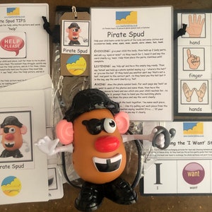 May include: A set of educational cards for children featuring a pirate-themed Mr. Potato Head character. The cards include images of body parts, clothing, and accessories, along with the corresponding words. The cards are designed to help children learn vocabulary and develop fine motor skills.