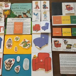 May include: A set of colorful educational flashcards for children featuring images of a pirate, a knight, a dragon, a ghost, a queen, a king, and a table. The cards are labeled with words like "who", "what doing", "what", and "where".
