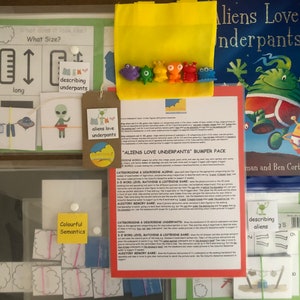 May include: A set of educational games for children featuring aliens wearing underpants. The set includes a book titled "Aliens Love Underpants", a game board, and various cards with pictures and words. The games are designed to help children learn about colors, shapes, sizes, and words.