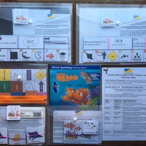 Puede incluir: Un conjunto de materiales educativos para niños con la película Buscando a Nemo. El conjunto incluye un libro de cuentos, un paquete de terapia y una bolsa de palabras con tarjetas. Los materiales están diseñados para ayudar a los niños a desarrollar su vocabulario y habilidades narrativas.
