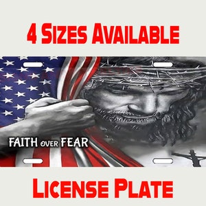 May include: A license plate featuring a black and white image of Jesus Christ with a crown of thorns, partially obscured by an American flag. The text "FAITH OVER FEAR" is printed on the flag.
