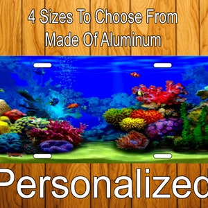 May include: Personalized aluminum license plate featuring an underwater scene with colorful coral reefs and fish. The text "4 Sizes To Choose From Made Of Aluminum" is at the top of the image.