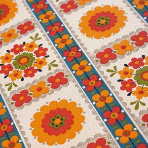 May include: A vintage wallpaper pattern with a repeating design of orange, red, and green flowers on a white background. The flowers are arranged in rows with a blue and white striped border.