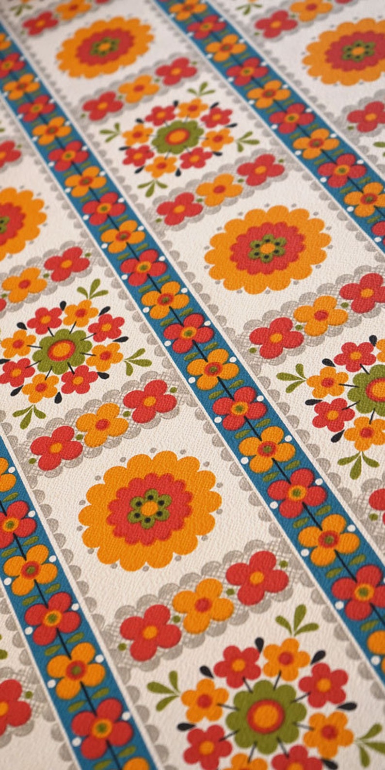 May include: A vintage wallpaper pattern with a repeating design of orange, red, and green flowers on a white background. The flowers are arranged in rows with a blue and white striped border.