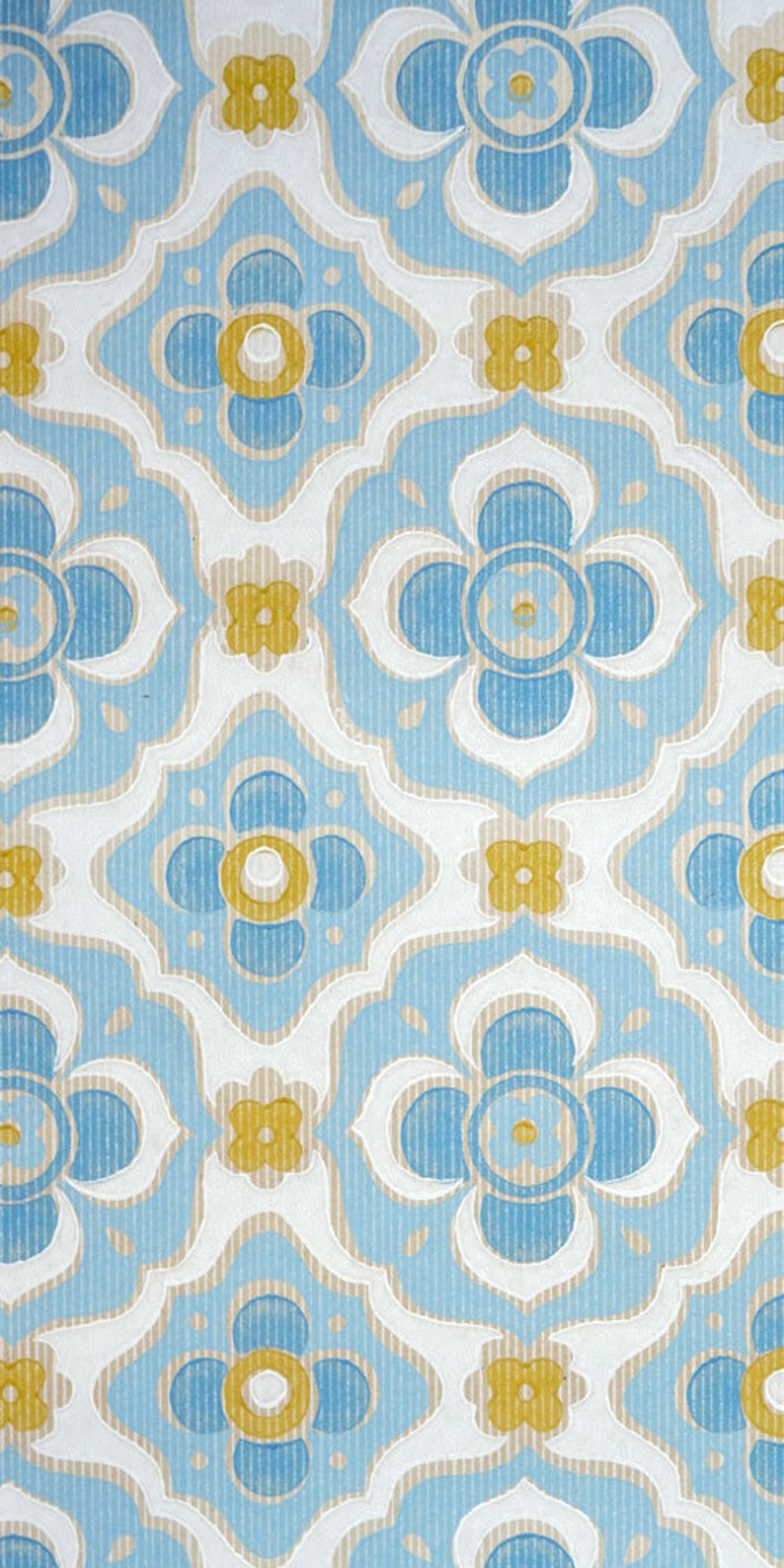 May include: A repeating pattern of blue and yellow flowers on a white background. The flowers have a stylised, geometric design and are arranged in a symmetrical pattern.