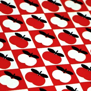 May include: A red and white checkered pattern with black apple silhouettes. The apples alternate between red and white.