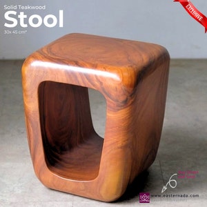 May include: A solid teakwood stool with a unique, rounded, open-box design. The stool is 30 x 45 cm and is made of natural wood with a rich brown color.