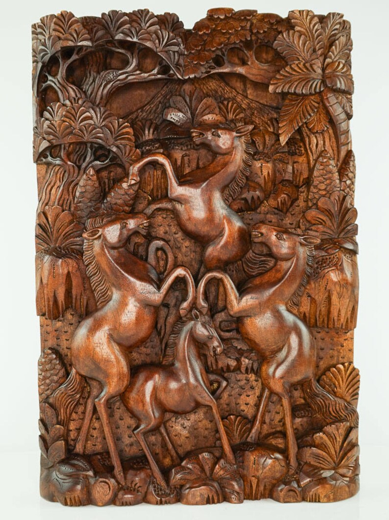 May include: A wooden wall sculpture depicting four horses in a jungle setting. The horses are carved in a realistic style and are shown in a dynamic pose. The sculpture is made of dark brown wood and has a natural finish.