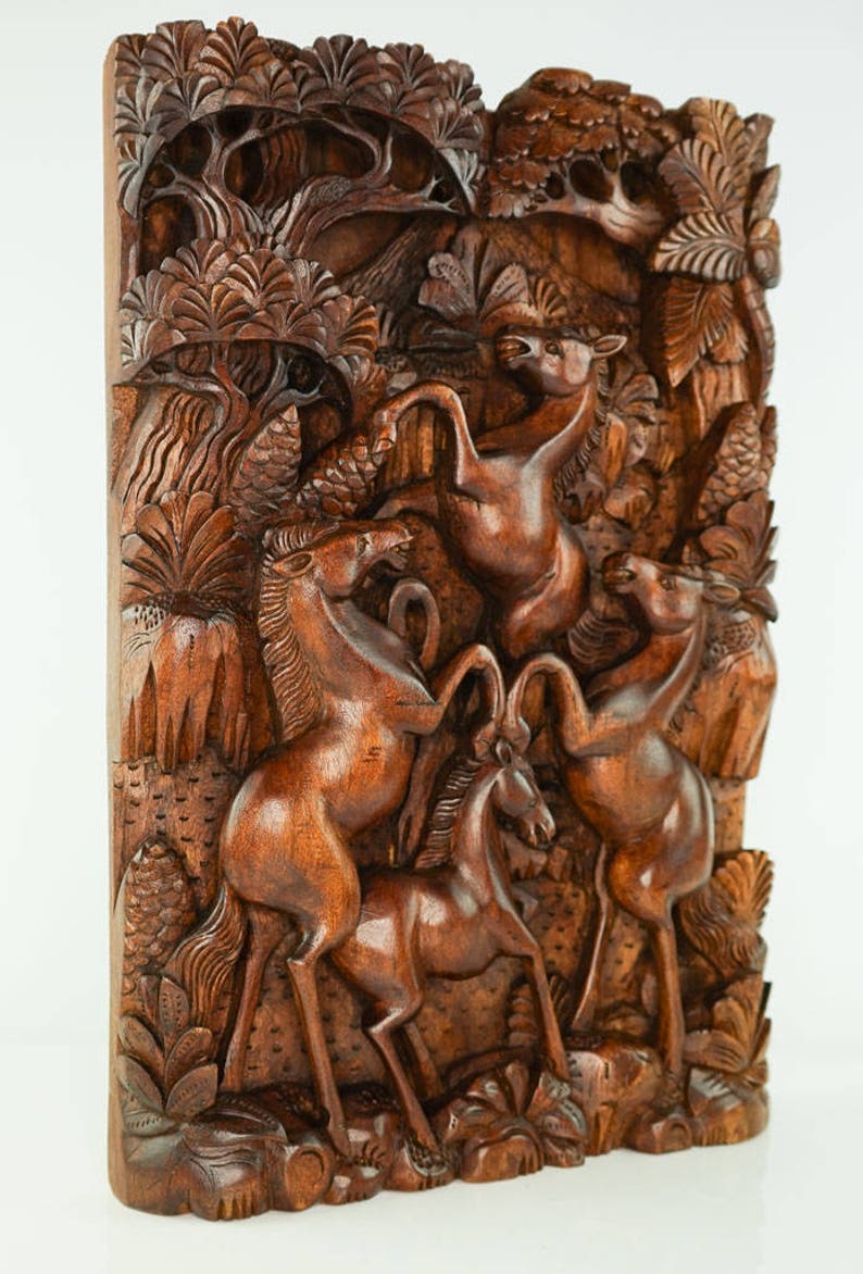 May include: A hand-carved wooden wall art piece depicting a scene of four horses in a forest. The horses are carved in a realistic style, with detailed features and flowing manes. The forest is carved with intricate details, including trees, leaves, and vines.