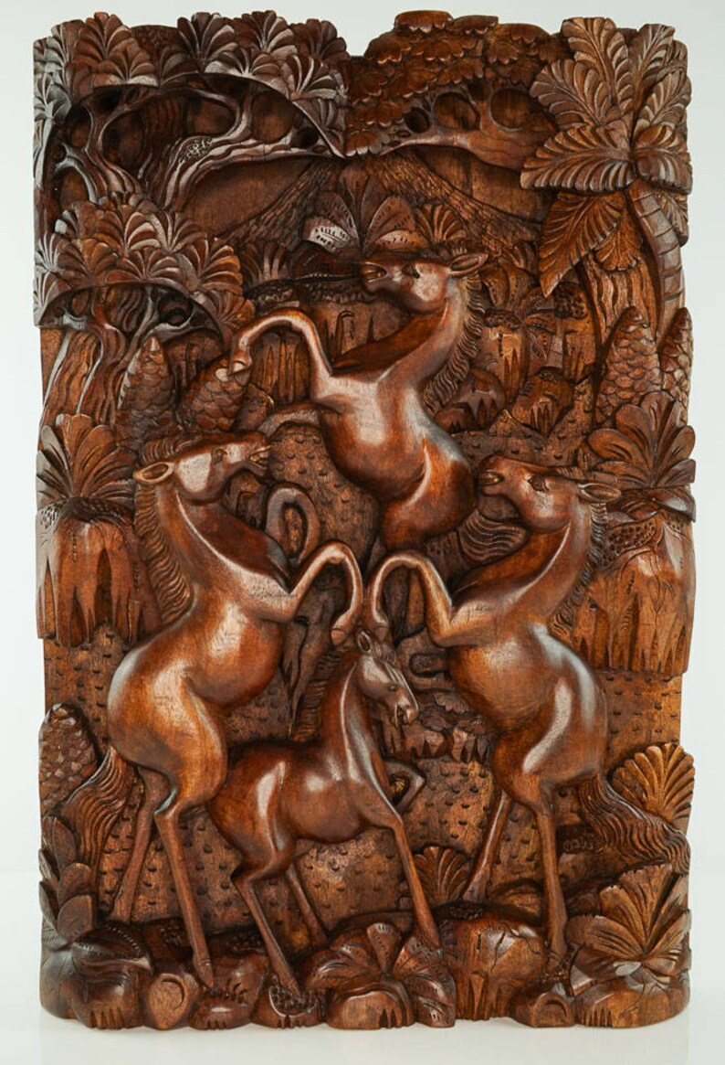 May include: A wooden wall sculpture depicting four horses in a jungle setting. The horses are carved in a realistic style and are shown in a dynamic pose. The sculpture is made of dark brown wood and has a rich, natural finish.