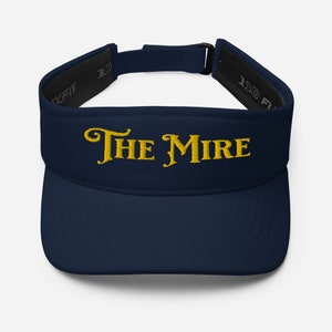 May include: A navy blue visor with a gold embroidered logo that says "THE MIRE".