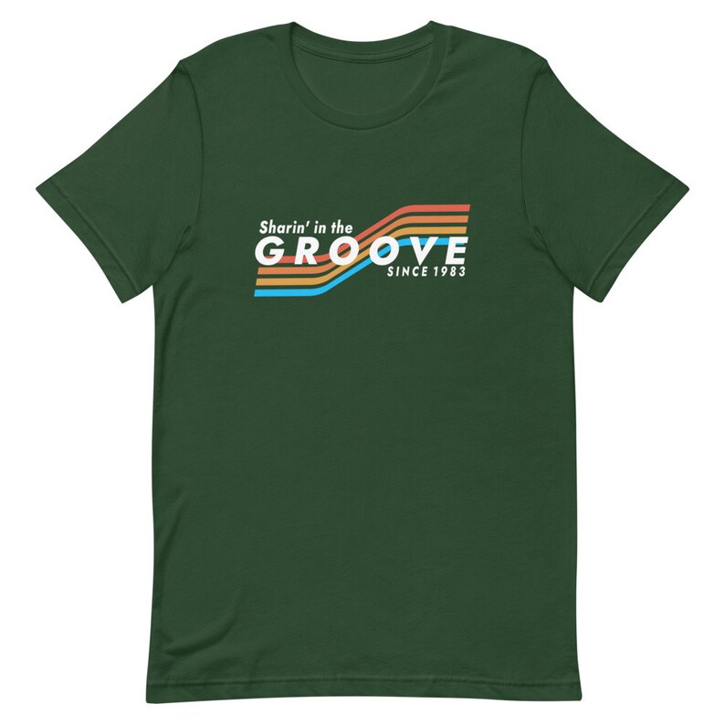 May include: A dark green t-shirt with a retro-style graphic that says "Sharin' in the GROOVE since 1983". The graphic features colorful stripes in orange, yellow, blue, and white.