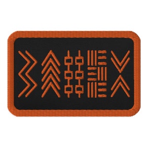 May include: Orange embroidered patch with a black background featuring a geometric design of arrows, squares, and lines.