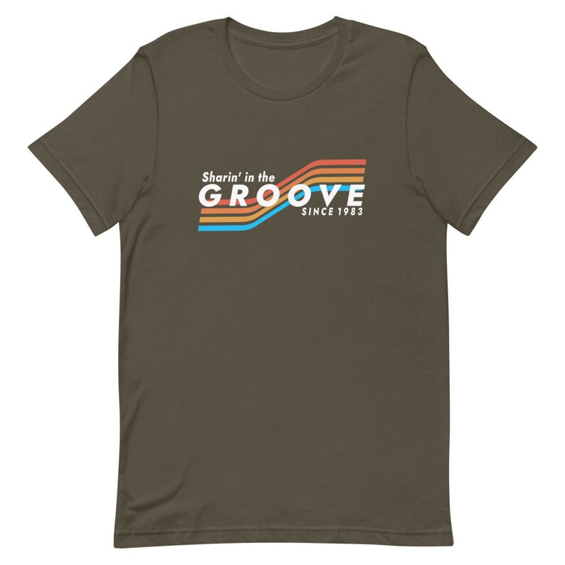 May include: A dark green t-shirt with a retro-style graphic that says "Sharin' in the GROOVE since 1983". The graphic features colorful stripes in orange, yellow, blue, and red.