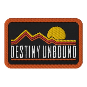 May include: An orange embroidered patch with a black background. The patch features a stylized sunset with mountains and the text "DESTINY UNBOUND".